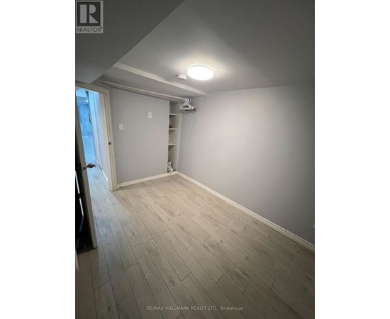 A room with a wooden floor and a white wall.