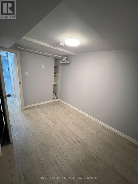 A room with a wooden floor and a white wall.