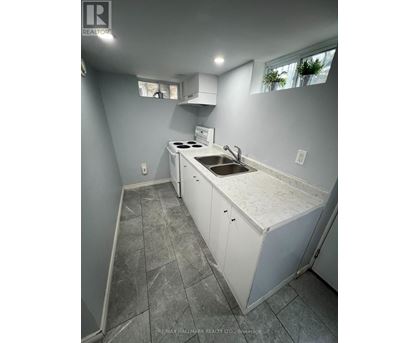 A kitchen with a white counter top and a sink.