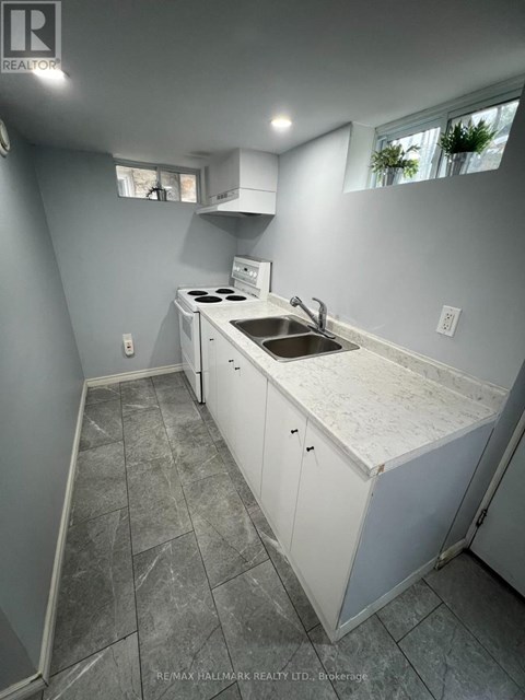 A kitchen with a white counter top and a sink.