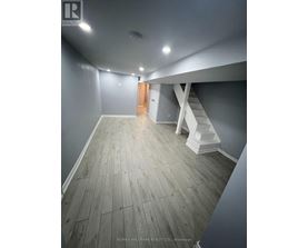 A hallway with wooden floors and white walls.