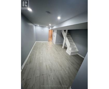 A hallway with wooden floors and white walls.