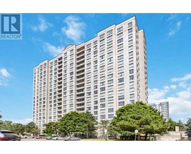 A tall residential building with a clear blue sky in the background.