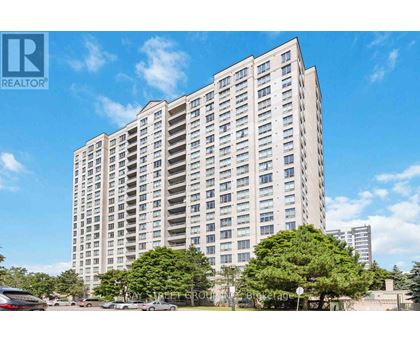 A tall residential building with a clear blue sky in the background.