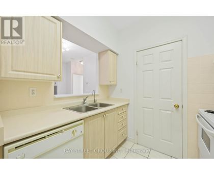 A kitchen with wooden cabinets and a white door.
