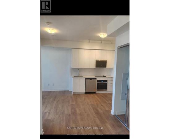 A kitchen with white cabinets and a wooden floor.