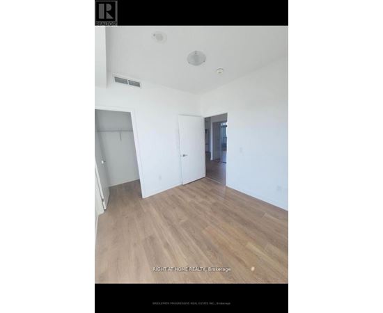 A room with wooden flooring and white walls.