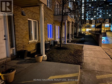 A nighttime view of a residential street with a RE/MAX Hallmark Realty Ltd. sign in the foreground.