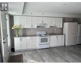 A kitchen with white cabinets and a stove top oven.