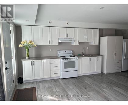 A kitchen with white cabinets and a stove top oven.