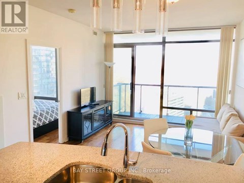 A kitchen with a sink and a window overlooking the city.