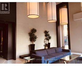 A living room with a couch, two potted plants, and two hanging lights.