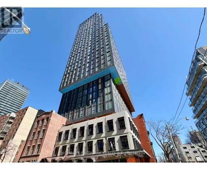 A tall building with a blue glass top stands out against the sky.