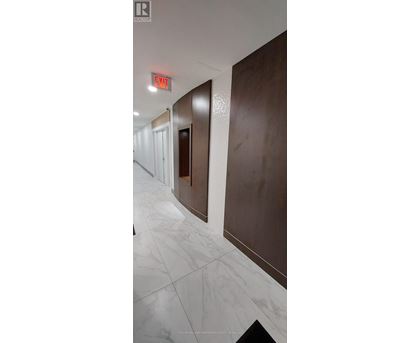 A hallway with a red exit sign above the door.