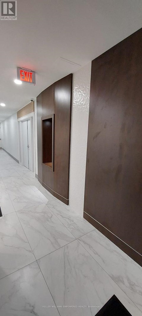 A hallway with a red exit sign above the door.