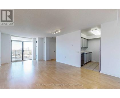 A spacious room with wooden flooring and white walls.