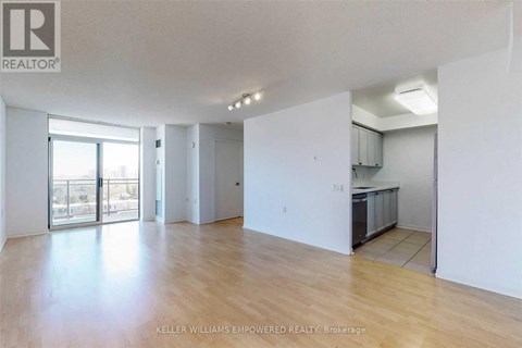 A spacious room with wooden flooring and white walls.