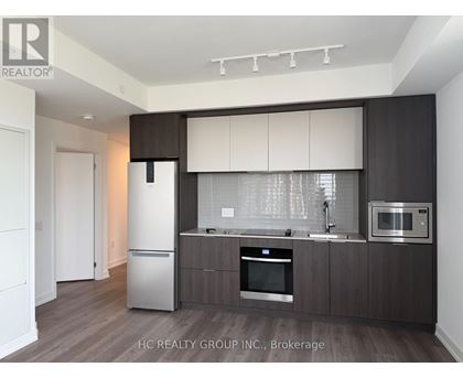 A modern kitchen with dark wood cabinets and stainless steel appliances.