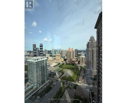 A cityscape with a mix of modern and older buildings, with a clear sky and a few clouds.