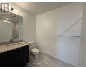 A bathroom with a toilet, sink, and mirror.