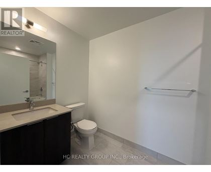 A bathroom with a toilet, sink, and mirror.