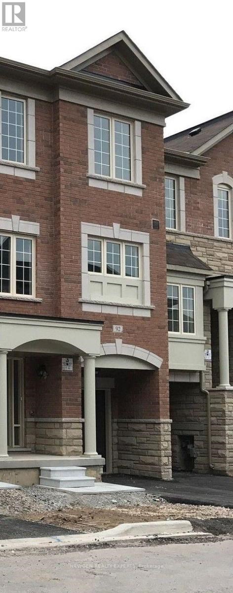 A two-story brick house with a white door and windows.