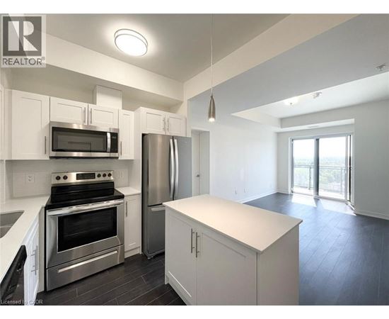 A modern kitchen with white cabinets and stainless steel appliances.