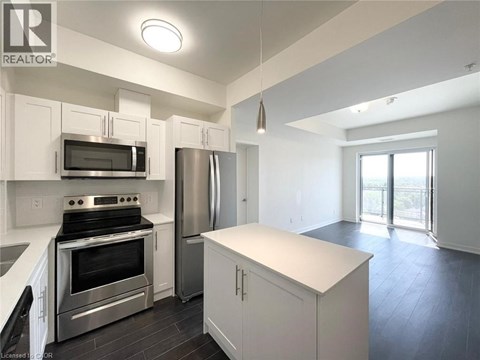 A modern kitchen with white cabinets and stainless steel appliances.