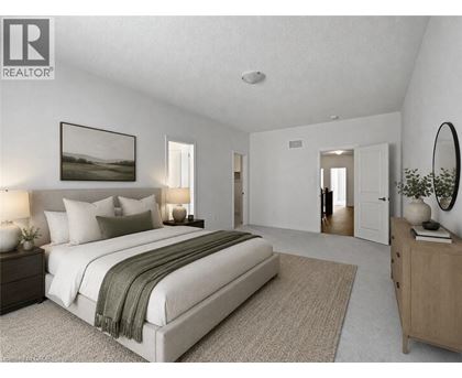 A bedroom with a large bed, a nightstand with a lamp, a dresser, and a mirror.