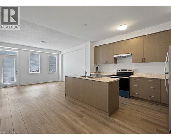 A kitchen with wooden floors and a refrigerator.