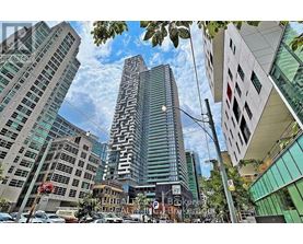 A tall building with a unique design stands out in a cityscape.