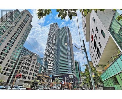 A tall building with a unique design stands out in a cityscape.