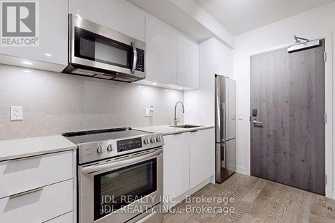 A kitchen with white cabinets and stainless steel appliances.