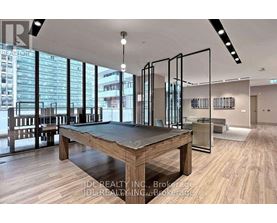 A room with a pool table and a view of the city.