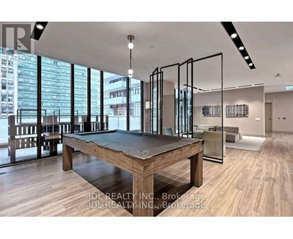 A room with a pool table and a view of the city.