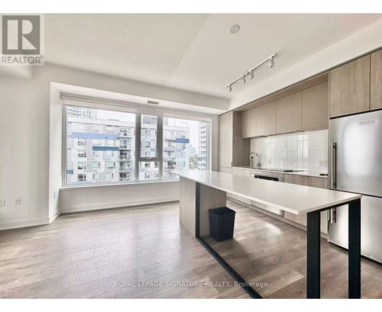 A modern kitchen with a large island and a view of the city.