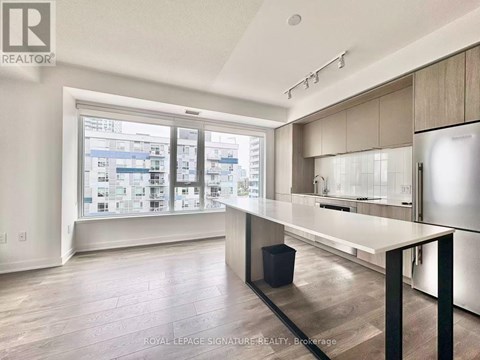 A modern kitchen with a large island and a view of the city.
