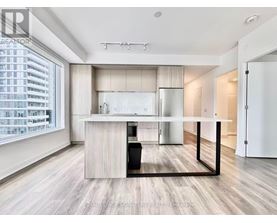 A modern kitchen with a large island and a dining table.