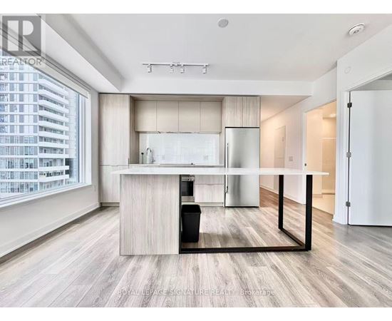 A modern kitchen with a large island and a dining table.