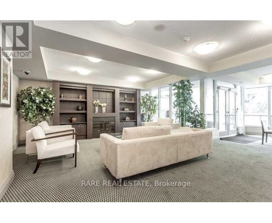 A living room with a couch, chair, and a fireplace.