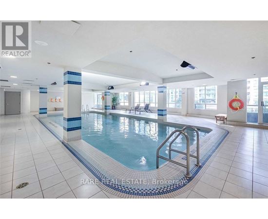 A large indoor swimming pool with a blue and white tiled edge.