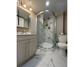 A bathroom with a marble floor and a walk-in shower.