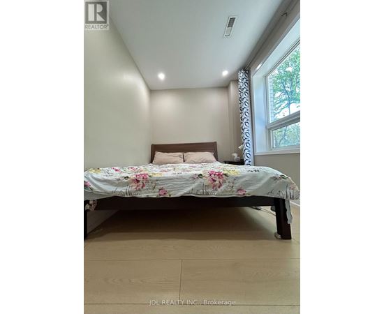 A bedroom with a bed and a window.
