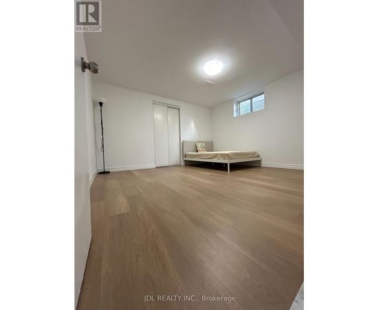 A room with wooden flooring and a bed in Brokerage.