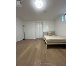 A bedroom with a bed, a door, and a window.