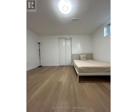 A bedroom with a bed, a door, and a window.