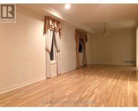 A room with wooden floors and a window with curtains.