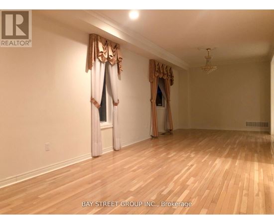 A room with wooden floors and a window with curtains.