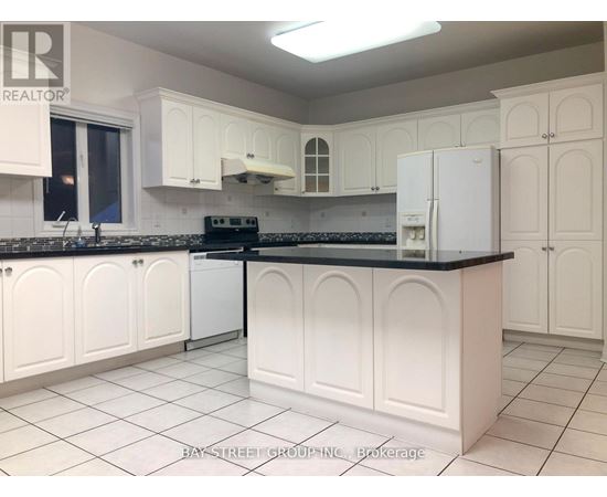 A kitchen with white cabinets and a black countertop.