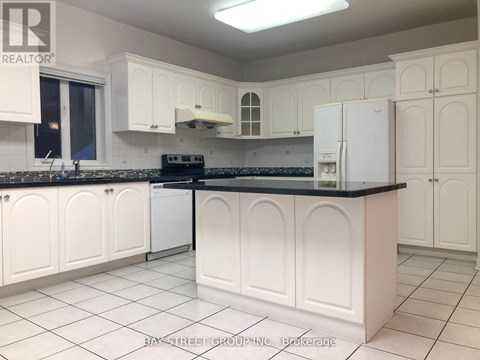 A kitchen with white cabinets and a black countertop.